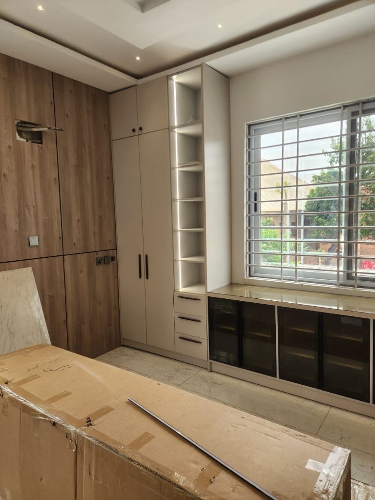 Built-in wardrobe with wood paneling and illuminated shelves